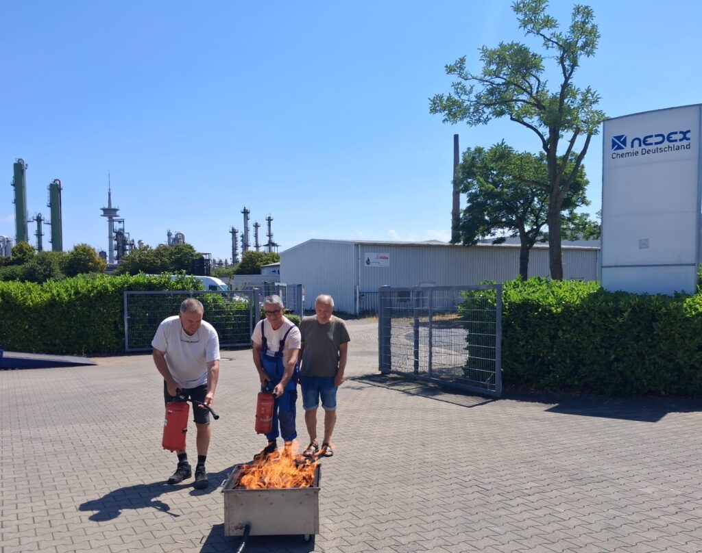 Praktische Feuerlöschübung für Brandschutzhelfer auf dem Betriebsgelände eines Unternehmens mit einem gasbefeuerten Übungsbrand.